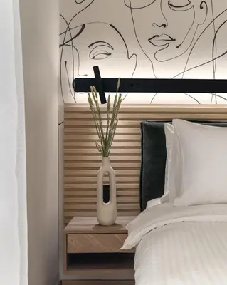 a white vase sitting on a night stand next to a bed at Phalerus Suites in Athens