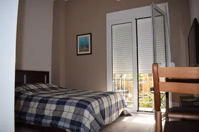 a bedroom with a bed and a window with blinds at Renovated City Center Studio in Athens