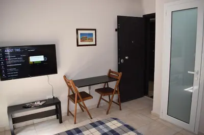 a room with a table and two chairs and a tv at Renovated City Center Studio in Athens