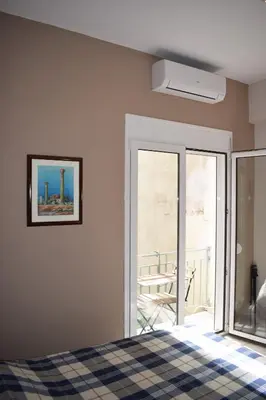 a bedroom with a bed and a view of a balcony at Renovated City Center Studio in Athens