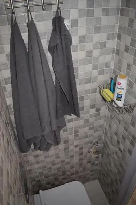 a bathroom with gray towels hanging on a wall at Renovated City Center Studio in Athens