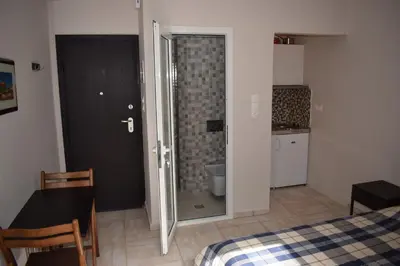 a bedroom with a bed and a door to a bathroom at Renovated City Center Studio in Athens