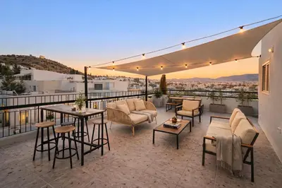 a patio with chairs and tables on a balcony at Lofos Lumina Suites in Athens