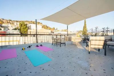 a patio with a table and chairs and yoga mats at Lofos Lumina Suites in Athens