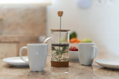 a vase with a plant in it next to two cups at Lofos Lumina Suites in Athens