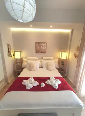 a bedroom with a large white bed with towels on it at Glory Appartment pippinou in Athens