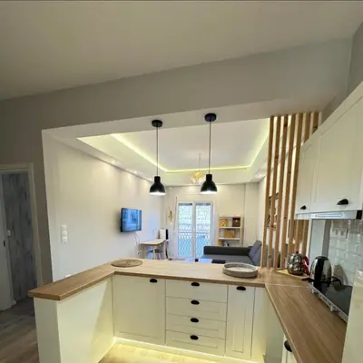 a kitchen with white cabinets and a counter top at Glory Appartment pippinou in Athens