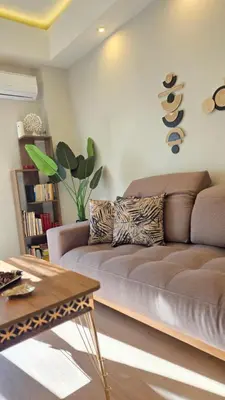a living room with a brown couch and a table at Glory Appartment pippinou in Athens