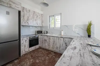 a kitchen with a wooden counter top and a refrigerator at Chris Guesthouses in Anavissos