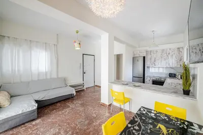 a living room with a couch and a kitchen at Chris Guesthouses in Anavissos