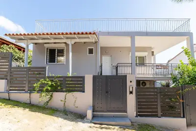 a house with a gate and a fence at Chris Guesthouses in Anavissos