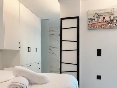 a bedroom with white cabinets and a mirror at Elysian Sunrise Retreat with pool in Porto Rafti