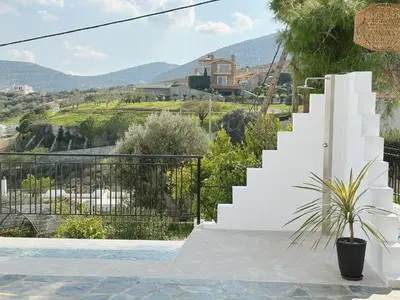 a villa with a staircase leading up to a house at Elysian Sunrise Retreat with pool in Porto Rafti