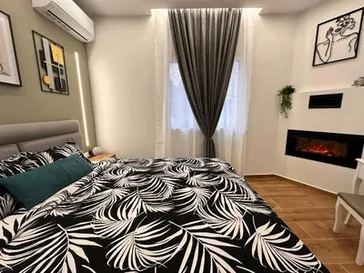 a bedroom with a black and white bed and a fireplace at Modern Bohemian Suites - GVM in Athens