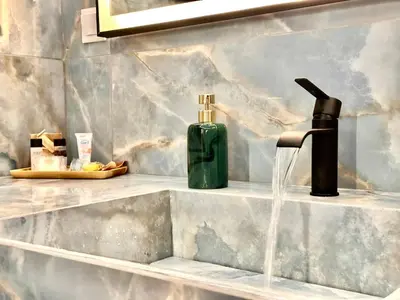 a bathroom sink with a soap dispenser on it at Modern Bohemian Suites - GVM in Athens
