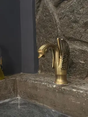 a gold faucet sitting on a stone wall at Modern Bohemian Suites - GVM in Athens