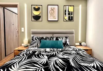 a bedroom with a bed with a black and white comforter at Modern Bohemian Suites - GVM in Athens
