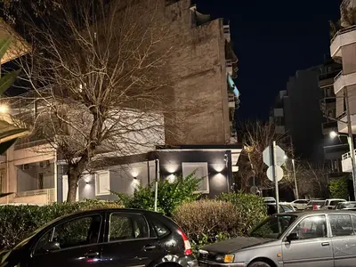 two cars parked on a city street at night at Modern Bohemian Suites - GVM in Athens