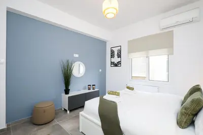 a bedroom with a white bed and blue walls at Acropolis Sights - Greecing in Athens