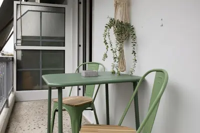 a green table and chairs in a room with a window at Acropolis Sights - Greecing in Athens