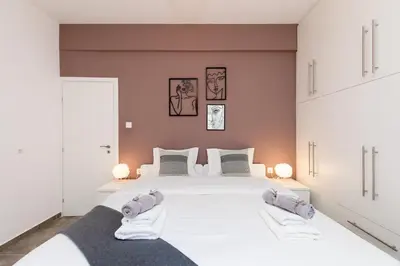 a bedroom with a large white bed with two pillows at Acropolis Sights - Greecing in Athens