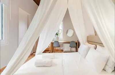 a bedroom with a white bed with white curtains at Acropolis 360 Residence,2 bedr in Athens