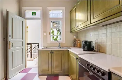a kitchen with wooden cabinets and a sink and a window at Acropolis 360 Residence,2 bedr in Athens