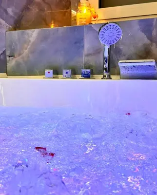 a bath tub filled with water with a blue fan at Modern Bohemian Suites ATHENS -- AVM in Athens