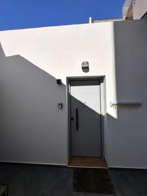 a door in a white wall with a blue sky at Modern Bohemian Suites ATHENS -- AVM in Athens
