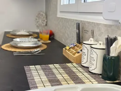 a kitchen counter with plates and utensils on a table at Modern Bohemian Suites ATHENS -- AVM in Athens