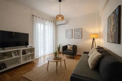 a living room with a couch and a tv at Koukaki lovely stay in Athens