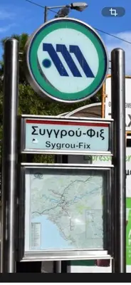 two signs on a pole with a sign for a suzuki dealership at Koukaki lovely stay in Athens