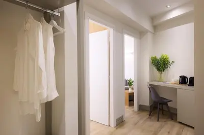 a room with a closet with a door and a chair at AthenSun Luxury Suites in Athens