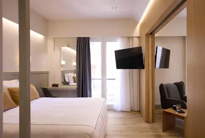 a hotel room with a bed and a television at AthenSun Luxury Suites in Athens