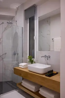 a bathroom with a sink and a shower at AthenSun Luxury Suites in Athens