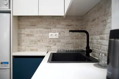 a kitchen with a sink and a brick wall at Seaside Golden Horizon VIPGreece in Athens