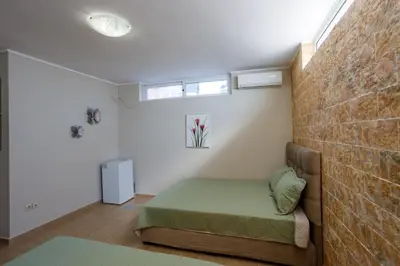 a bedroom with a bed and a brick wall at Villa Vegera in Anavissos