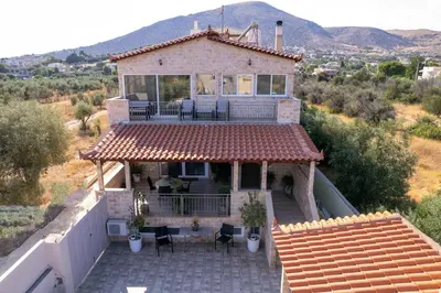 a house with a roof with a patio and a balcony at Villa Vegera in Anavissos