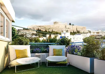 a balcony with two chairs and a view ofhens at Historic Elegance in Acropolis in Athens