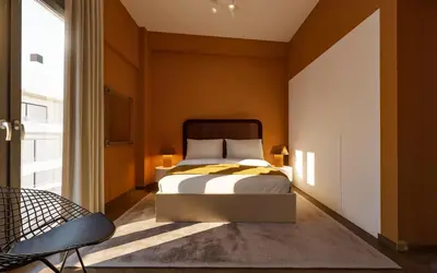 a bedroom with a bed with orange walls at Historic Elegance in Acropolis in Athens