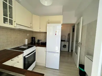 a kitchen with white cabinets and a white refrigerator at The Katehaki Comfort Hub in Athens