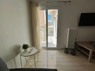 a living room with a table and a glass door at The Katehaki Comfort Hub in Athens