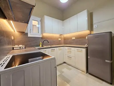 a kitchen with white cabinets and a stainless steel refrigerator at EL Prestige Apartment - Athens Town in Athens