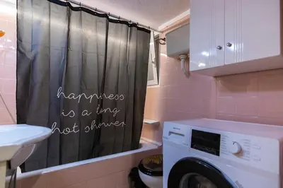 a bathroom with a shower curtain that says happiness is a ring not stirred at Prime and Cosy 1bedroom Hop to Acropolis in Athens