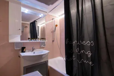 a bathroom with a black shower curtain and a sink at Prime and Cosy 1bedroom Hop to Acropolis in Athens