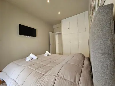 a bedroom with a large bed with a tv on the wall at J&G Luxury Apartment - Athens Town in Athens