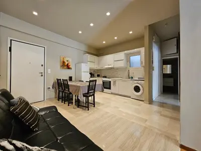 a living room and kitchen with a table and chairs at J&G Luxury Apartment - Athens Town in Athens