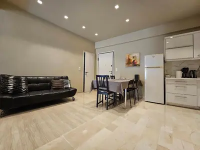 a living room with a black leather couch and a table at J&G Luxury Apartment - Athens Town in Athens