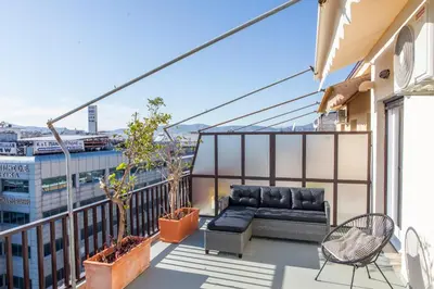 a balcony with a couch and chairs on a building at Lucas apartment 3 in Athens