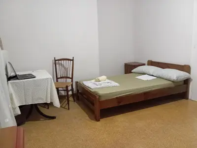 a bedroom with a bed and a table and a chair at Room for 2 persons next to metro in Athens